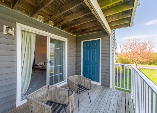Covered porch with two chairs and a blue door at Wrights Point, Ft Wright