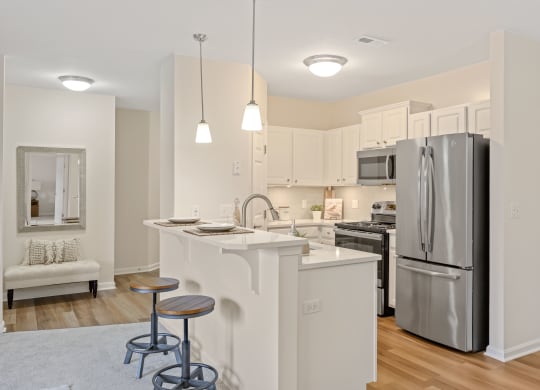 a kitchen with an island and two stools at Roebling Row, Covington, KY, 41011-1720