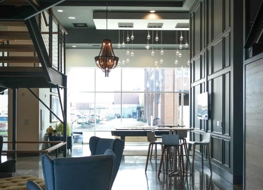 a living room with blue chairs and a table in a lobby