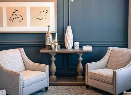 a living room with blue walls and chairs and a chandelier