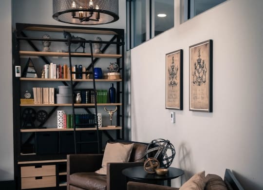 a living room with a couch and chairs and a book shelf