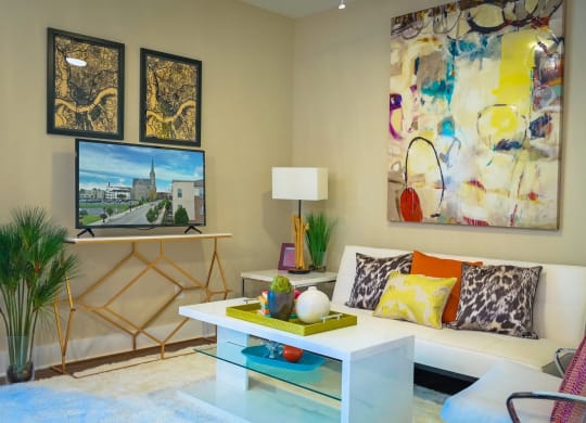 a living room with a white coffee table and colorful pillows
