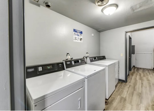 a laundry room with four washers and two dryers