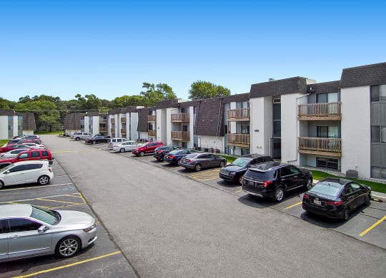 a row of apartment buildings with cars parked in front of them