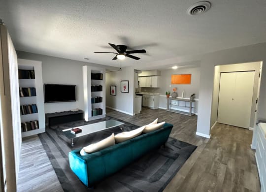 a living room filled with furniture and a ceiling fan