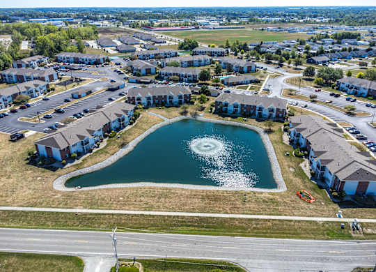 A bird's eye view of a residential area with a lake in the middle.