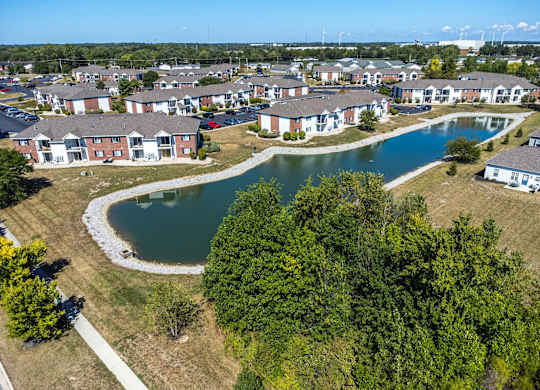 A bird's eye view of a residential area with a pond and trees.