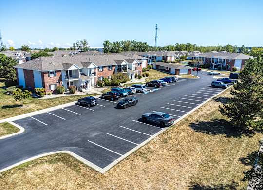 A parking lot with cars and apartment buildings in the background.