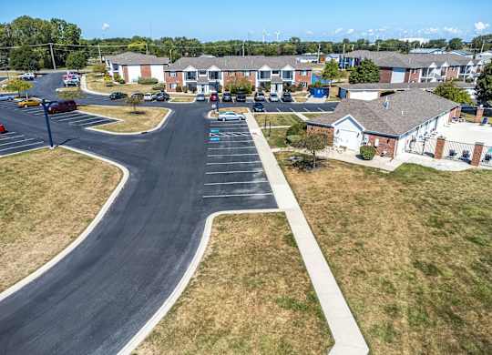 A road with a white line on the side and cars parked on the side.