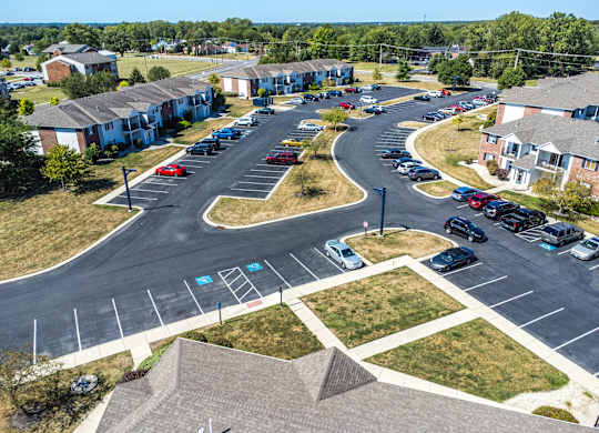 A parking lot with cars and apartment buildings in the background.