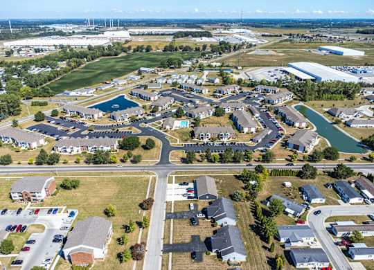 A bird's eye view of a residential area with houses, roads, and a swimming pool.