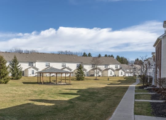 a park with a gazebo in front of a row of houses at Traditions at Slate Ridge, Reynoldsburg, OH