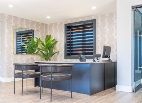 an office with two stools and a desk with a computer