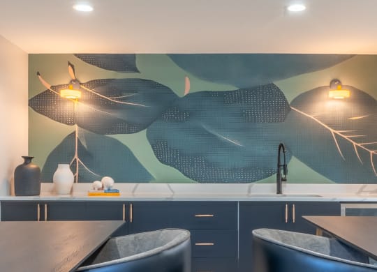 a kitchen with blue cabinets and a painting on the wall
