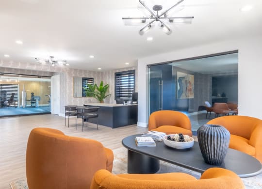 a living room with orange chairs and a table
