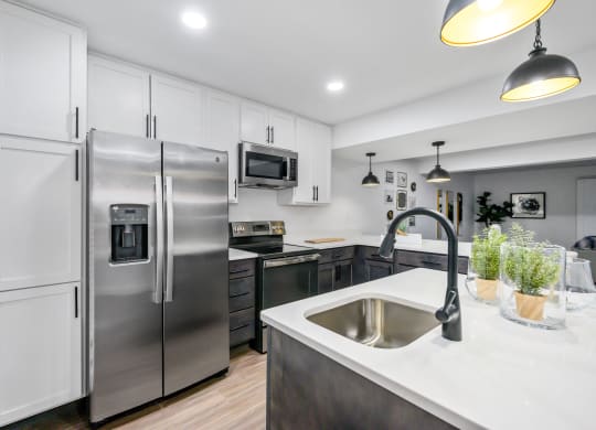 a kitchen with white cabinets and stainless steel appliances