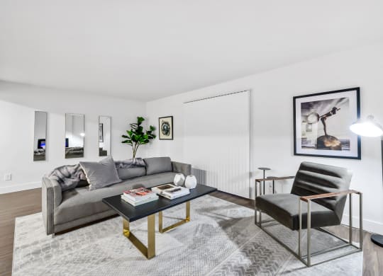a living room with white walls and hardwood floors