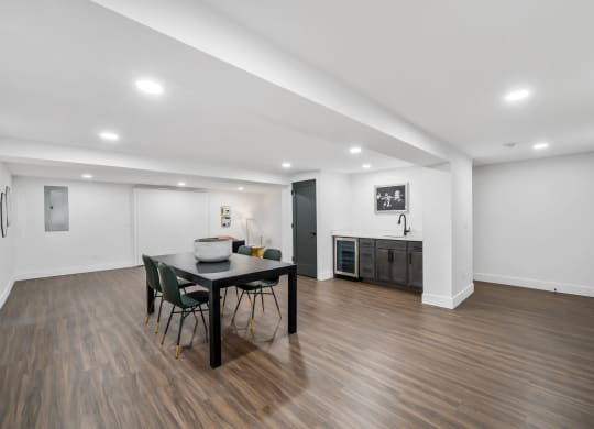 a dining area with a table and chairs and a kitchen in the background