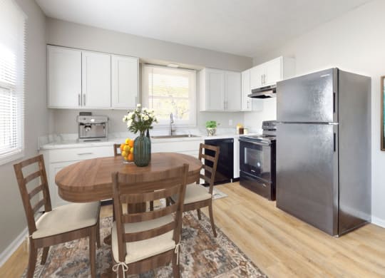 a kitchen with a table and a refrigerator at Stonebrook of Franklin, Franklin, IN, 46131