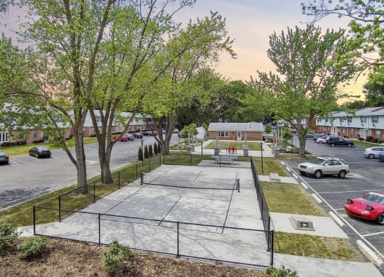 a tennis court in the middle of a parking lot