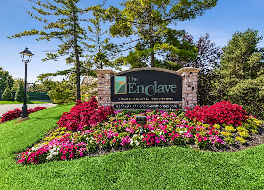 The Enclave sign is surrounded by a beautiful flower bed.
