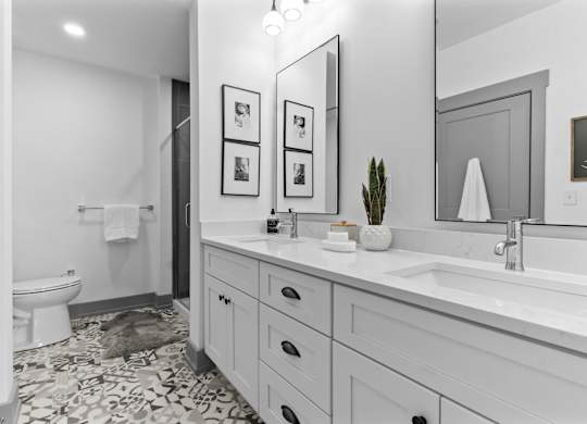 A bathroom with a white toilet, a sink, and a mirror. at The Ridge Apartments, Cincinnati, OH, 45213