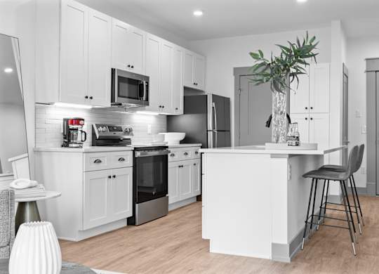 A modern kitchen with white cabinets and stainless steel appliances. at The Ridge Apartments, Cincinnati, OH