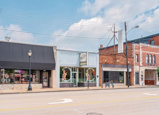 A street view of a small town with a variety of shops. at The Ridge Apartments, Ohio, 45213