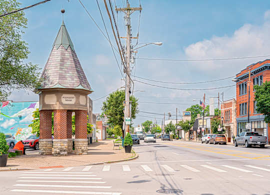 A small brick tower with a green roof stands in the middle of a street. at The Ridge Apartments, Cincinnati, OH