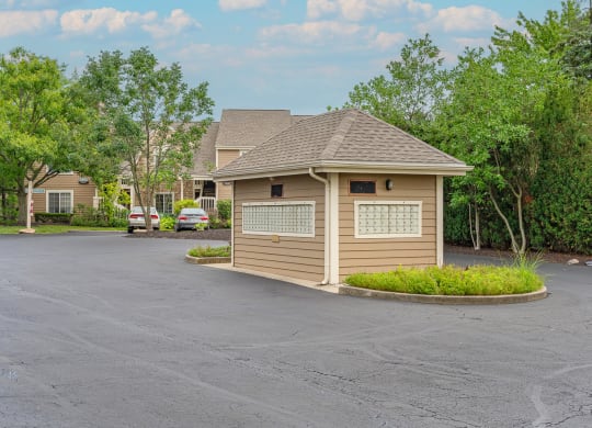 a small building in a parking lot with trees in the background at Enclave, Beavercreek, Ohio