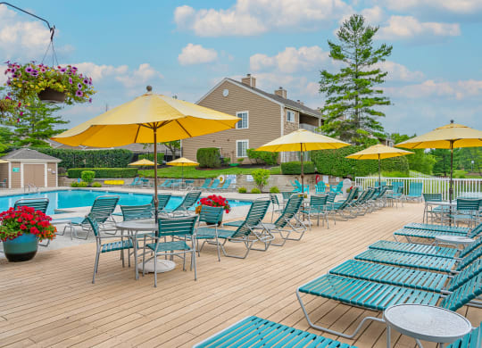 a swimming pool with chaise lounge chairs and umbrellas at Enclave, Ohio, 45431