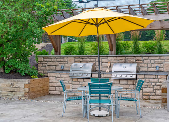a patio with a table and chairs under an umbrella at Enclave, Beavercreek, 45431
