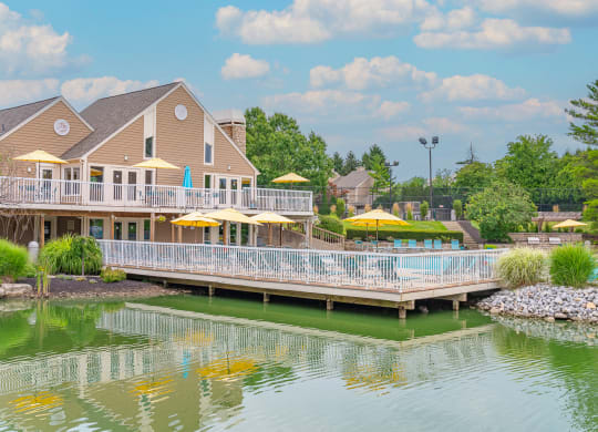 a house on the water with a large deck with umbrellas at Enclave, Beavercreek, Ohio