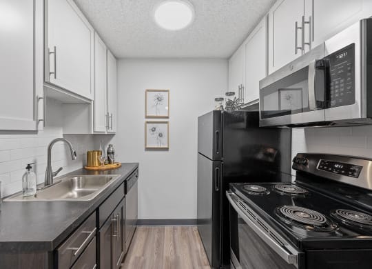 Kitchen with white cabinetry and black appliances  at Timber Glen Apartments, Ohio