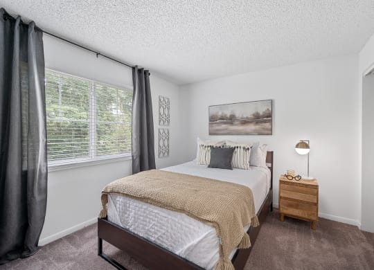 Bedroom with a bed and a nightstand  at Timber Glen Apartments, Batavia, 45103