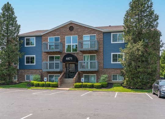 an apartment building with a parking lot in front of it