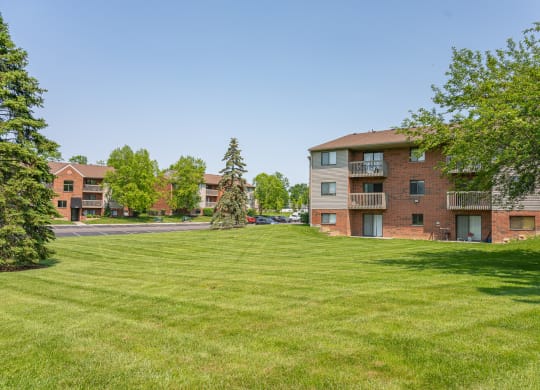 a green lawn in front of an apartment building