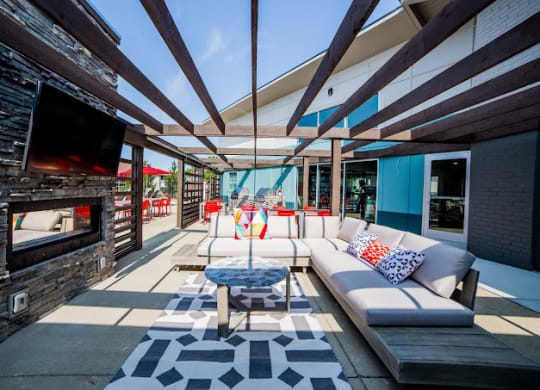 a patio with a couch and a coffee table in front of a fireplace at 7 Pointe Apartments, Indianapolis, IN, 46205