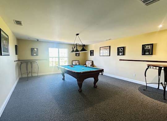 A pool table is in the middle of the room.