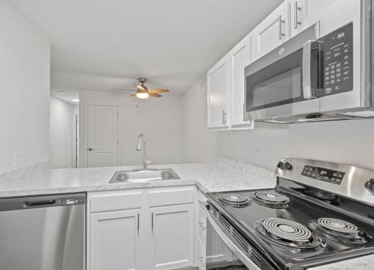 a kitchen with white cabinets and stainless steel appliances and a sink