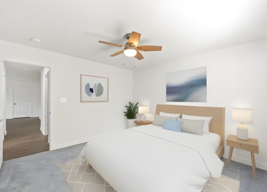 a bedroom with a large white bed and a ceiling fan