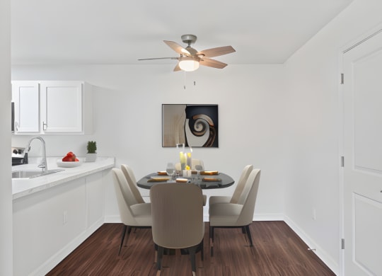 a dining room with a table and chairs and a ceiling fan