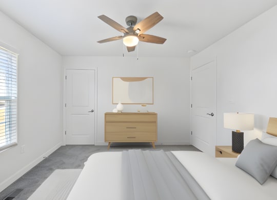 a white bedroom with a bed and a ceiling fan