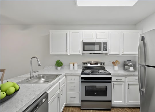 an apartment kitchen with stainless steel appliances and white cabinets
