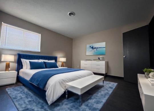 a bedroom with a blue and white bed and a blue rug