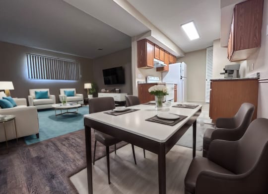 a living room and kitchen with a table and chairs