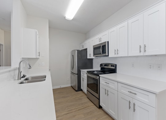 a white kitchen with stainless steel appliances and white cabinets at Four Bridges, Liberty Township, 45044-8380