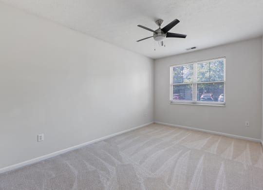 an empty living room with a ceiling fan and a window at Four Bridges, Liberty Township, Ohio