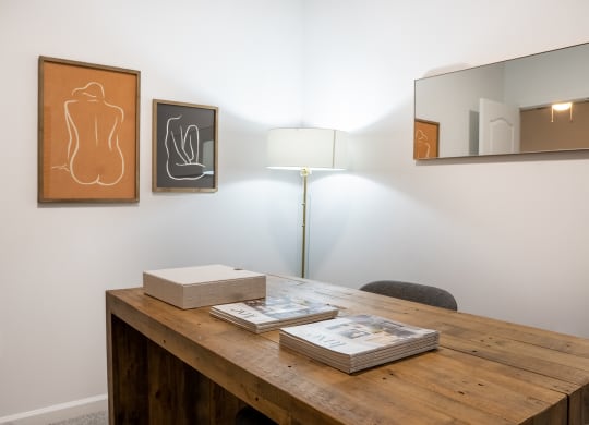 a desk with books and a lamp in a room with paintings on the wall  at Waterstone Landing, Ohio, 43551