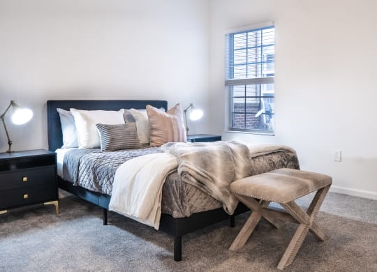 a bedroom with a bed and a stool in front of a window  at Waterstone Landing, Ohio, 43551